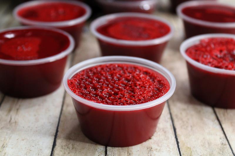 Close up of jello shot showing foamy red jello shot. 