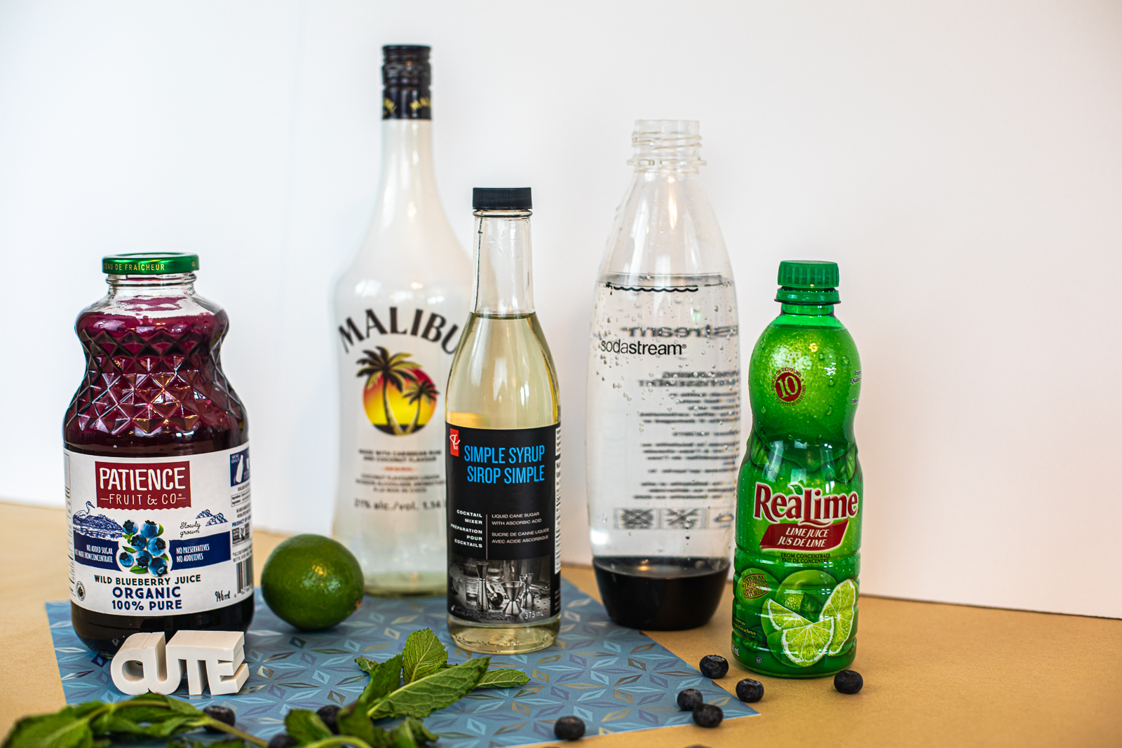Ingredients needed to make Blueberry Breeze Cocktail : blueberry juice, Malibu rum, simple syrup, soda water, and lime juice. Fresh mint and blueberries all around. 