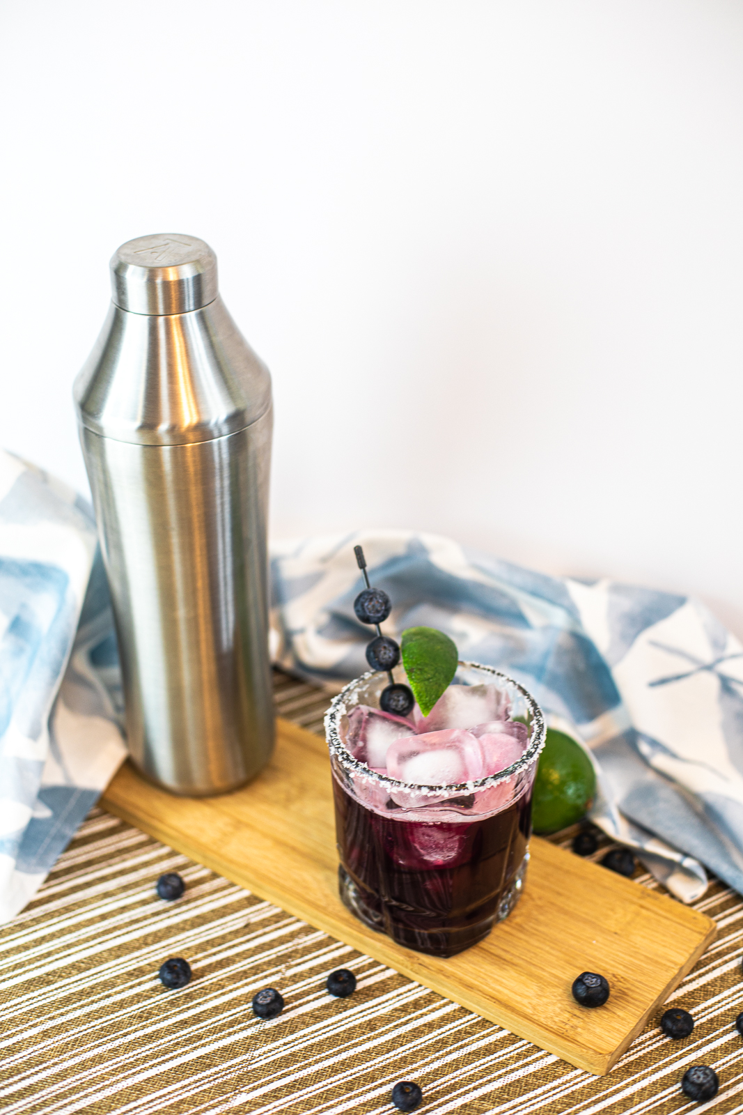 Blueberry Margarita with salted rim, blueberries and lime wedge as garnish. 