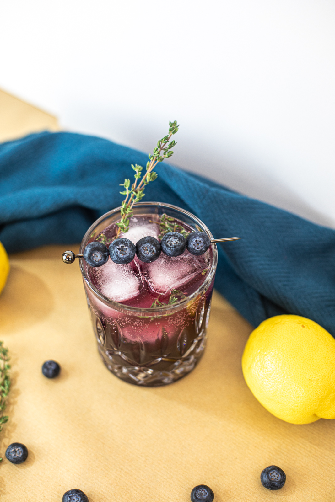 Above view of cocktail with thyme and blueberries as garnish. 