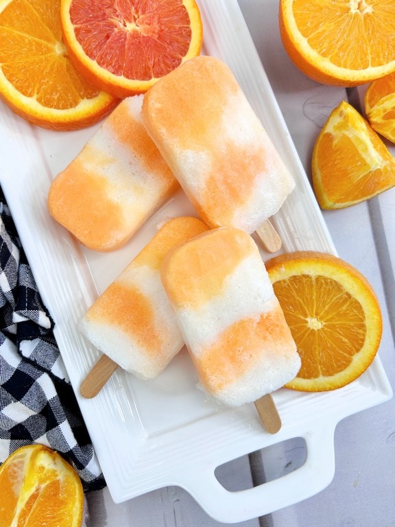 close up of popsicles showing the layers. White, orange, white, and orange. 
