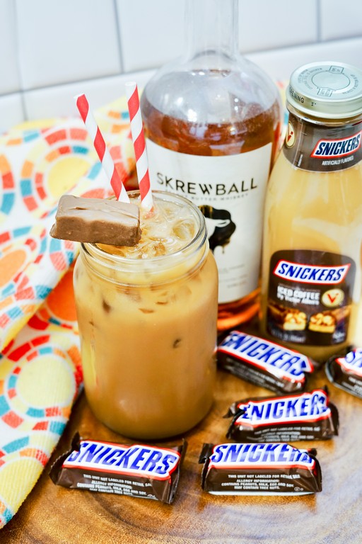 Boozy Snickers Iced Coffee - Cocktail filled with tons of ice, straws and a mini snickers chocolate bar as garnish. 