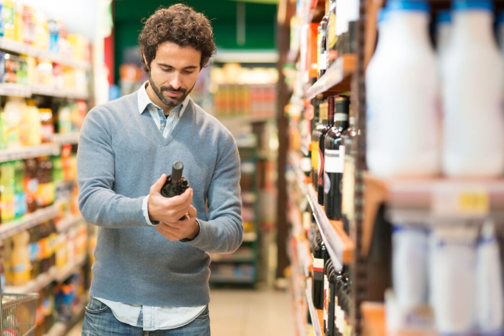 Man deciding on wine to buy at a grocery store