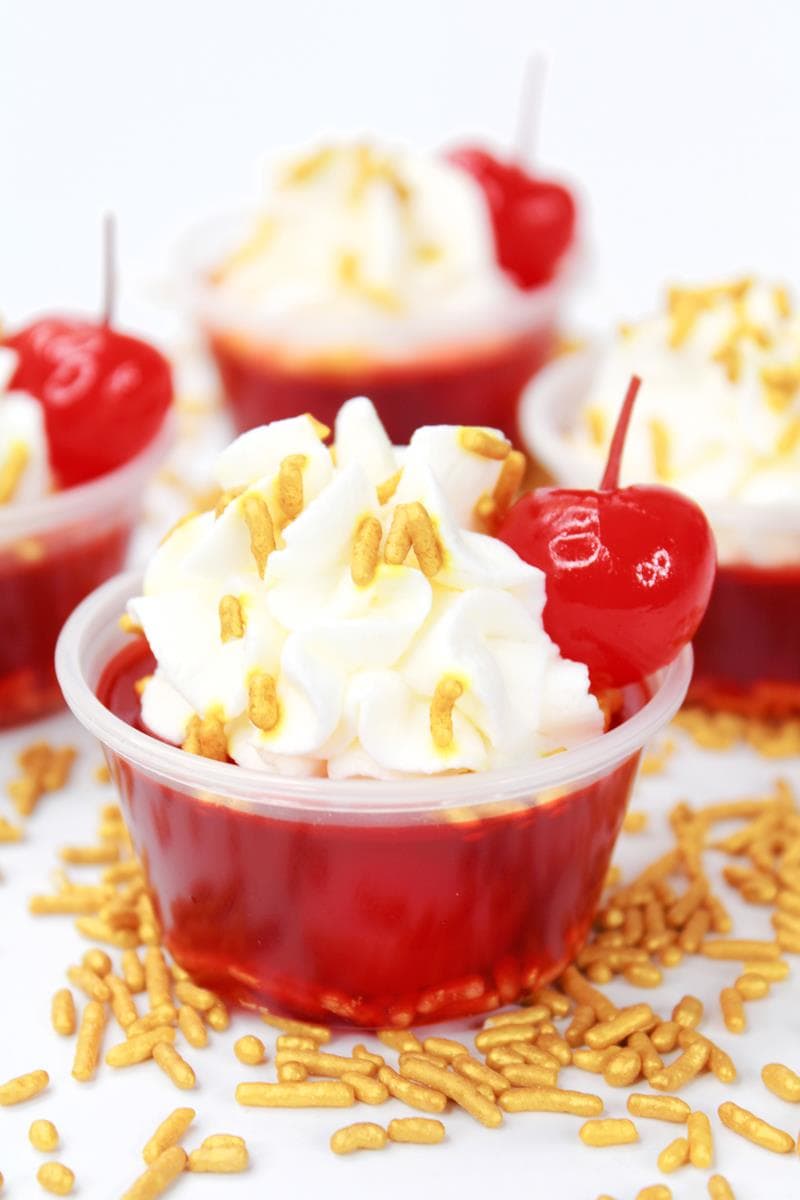 Cherry flavored jello shooter with cream and cherries