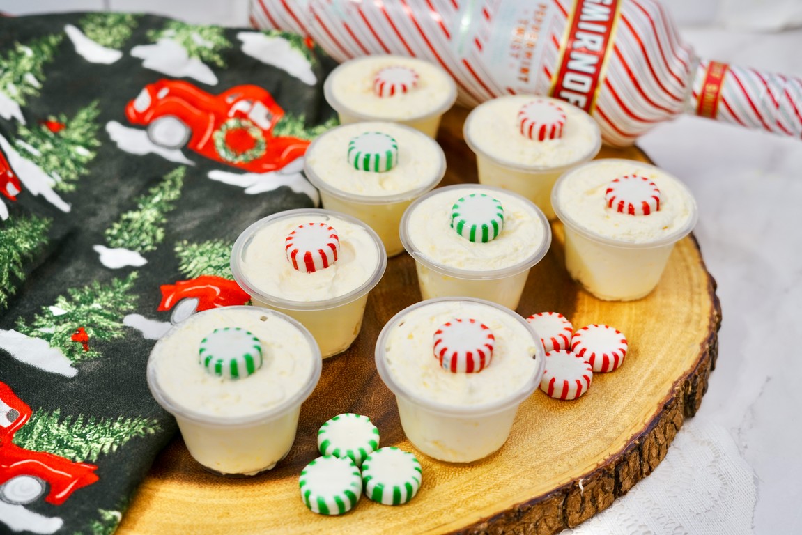 Peppermint Twist Pudding Shots - wooden round slab with various pudding shots on them. 