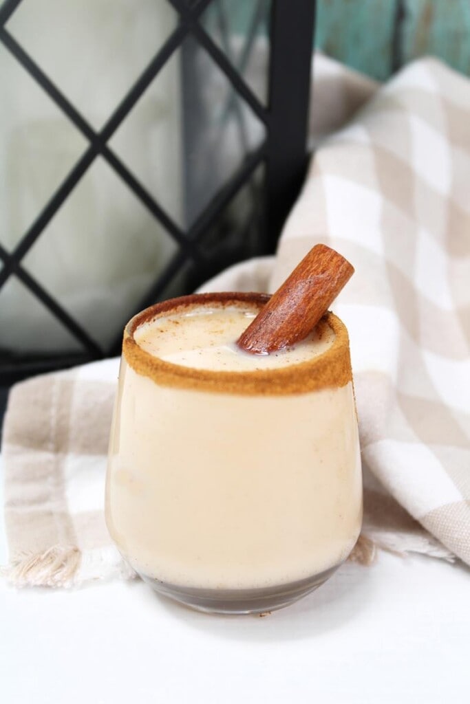 showing close up of churro shot with cinnamon around rim and cinnamon stick sticking out. 