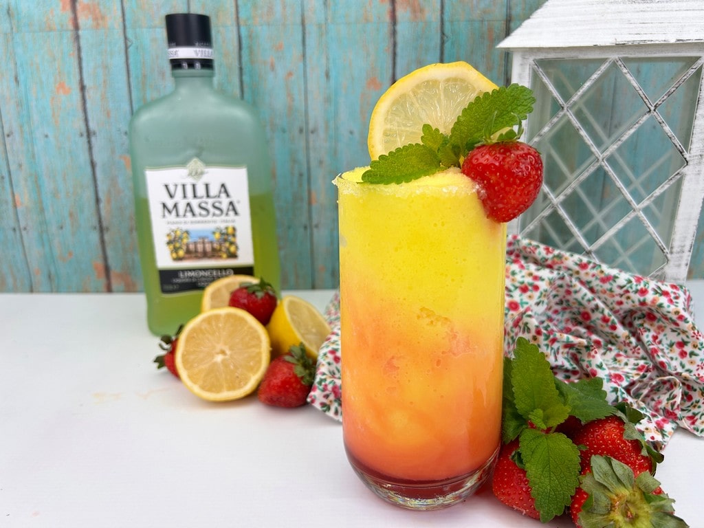 Frozen Strawberry Lemonade Cocktail - Finished cocktail with lemons and strawberries in the background. 