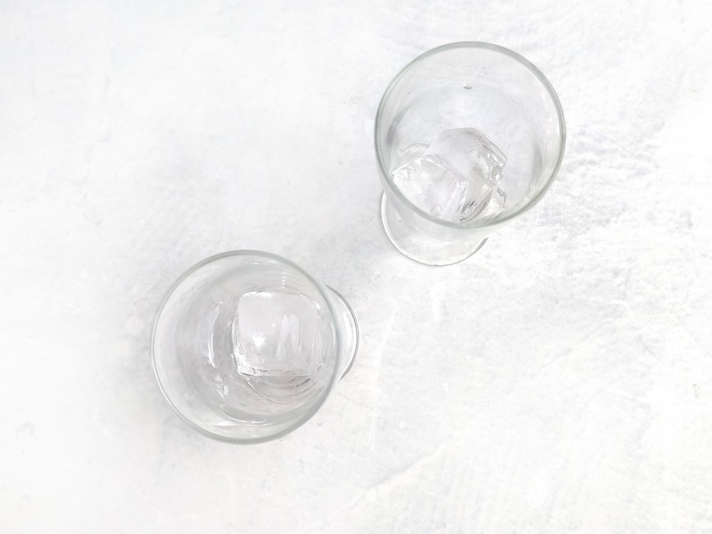 Above view of two wine glasses filled with ice cubes. 