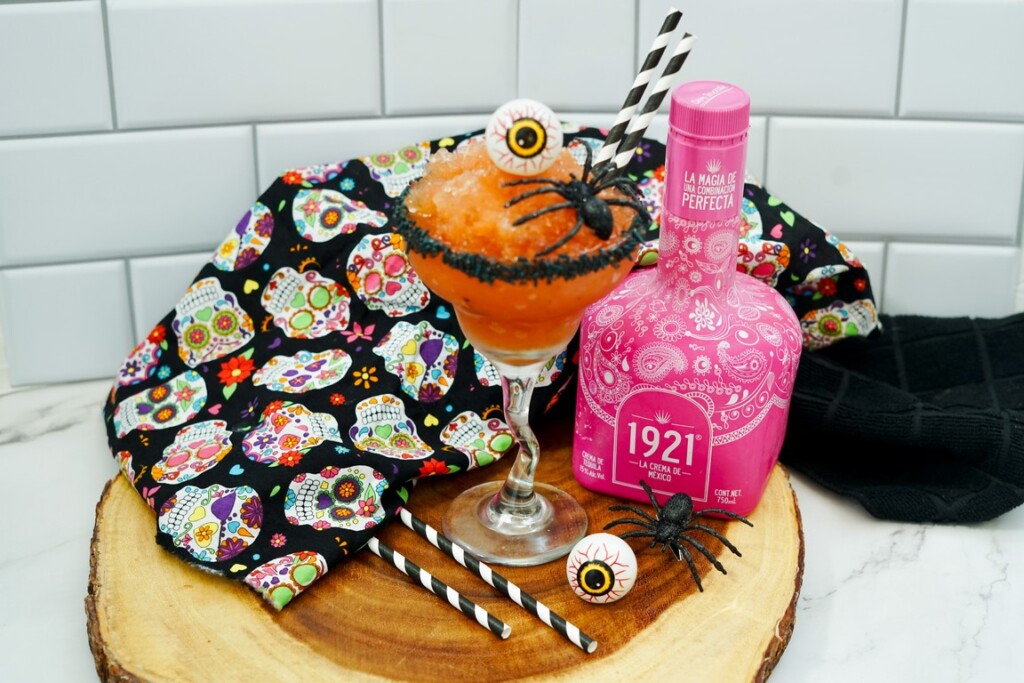 Halloween Strawberry Margarita - cocktail, skull towel, straws, and plastic spider and eyeballs around. 