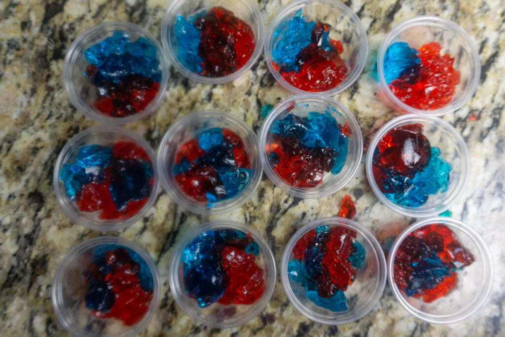 Set of Jello shots lined up in plastic cups with 4th of July colors