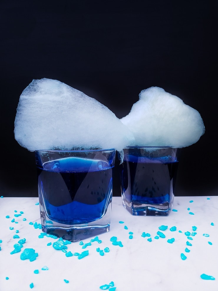 two finished cocktails showing large cotton candy on top. 