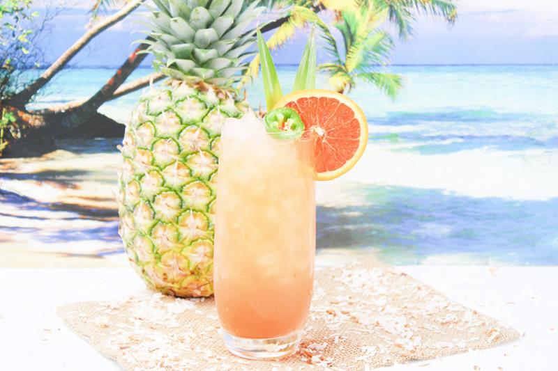 beach scene with clear tall class with mango firing squad cocktail 