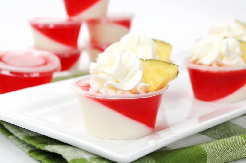 close up of miami vice jello shot with whipped cream and pineapple piece 