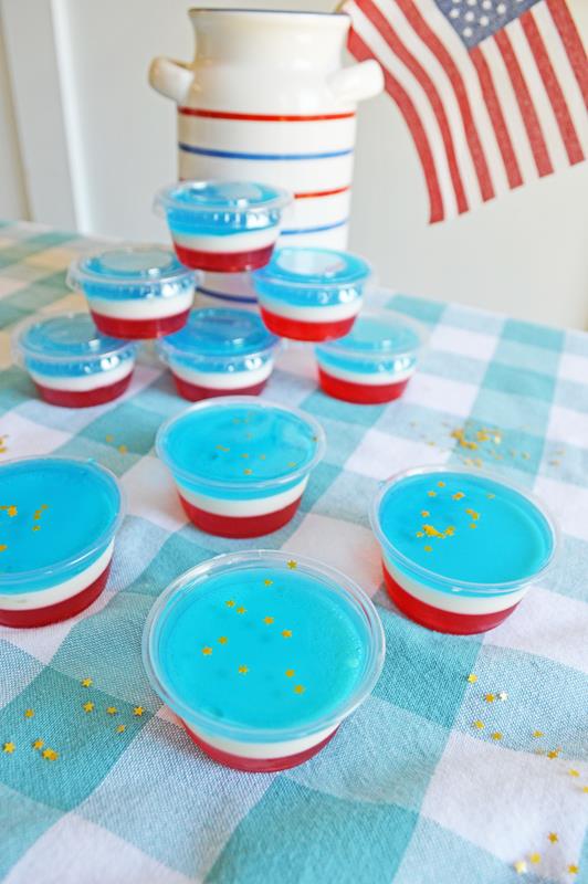 vodka jello shooters in dessert cups arranged on a tablecloth with an American flag 