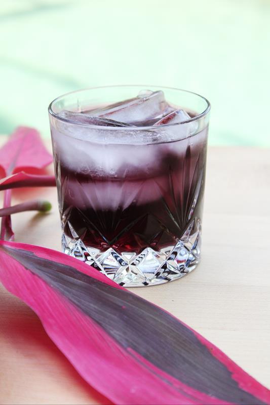 short glass with purple passion punch drink 