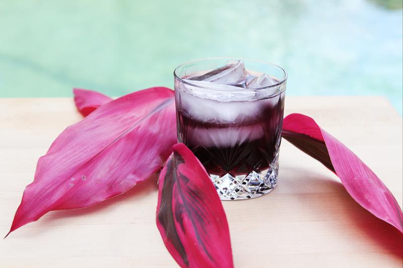 glass filled with purple passion punch drink with ice 