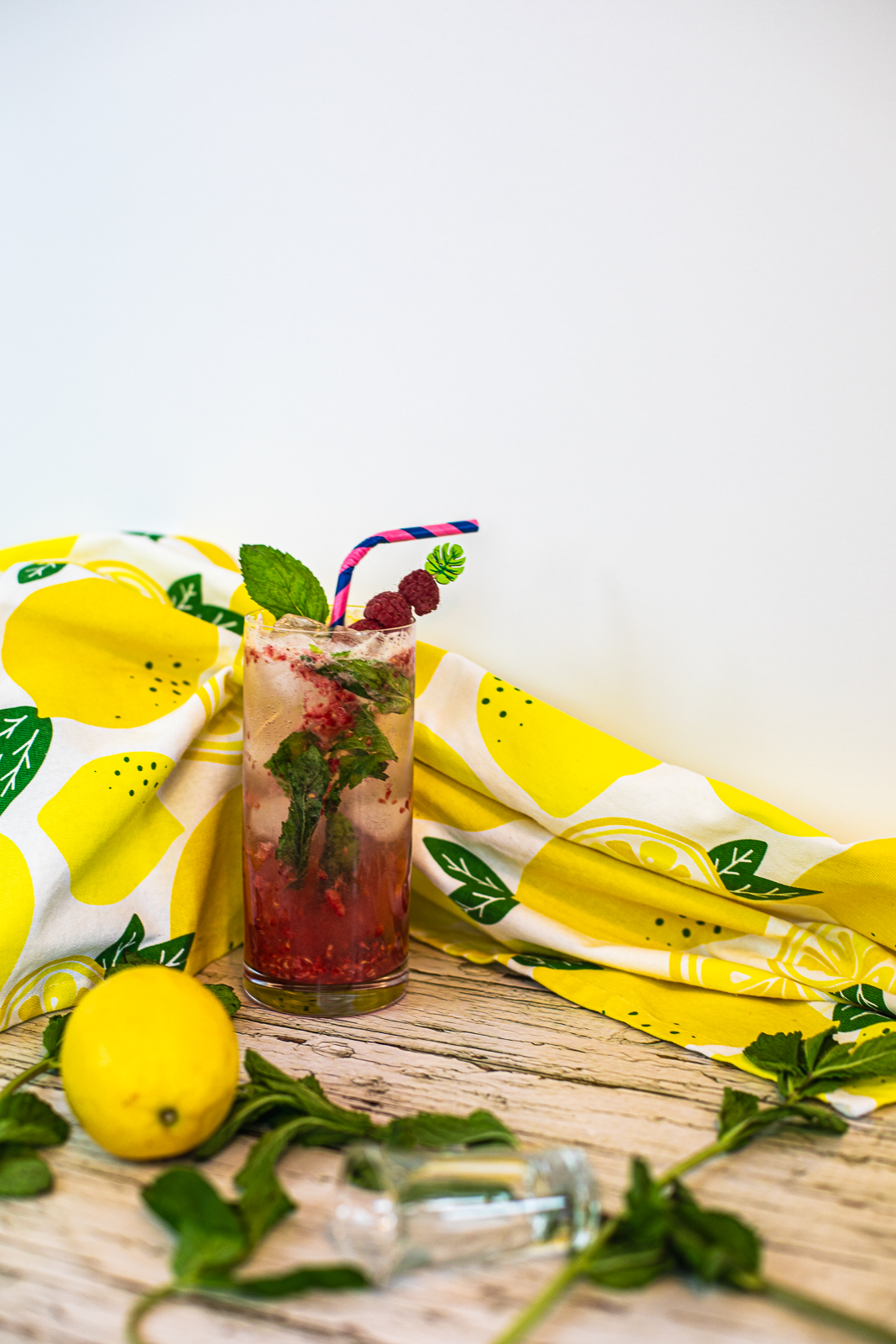 Finished Raspberry Mojito Cocktail in front of a lemon tea towel. 