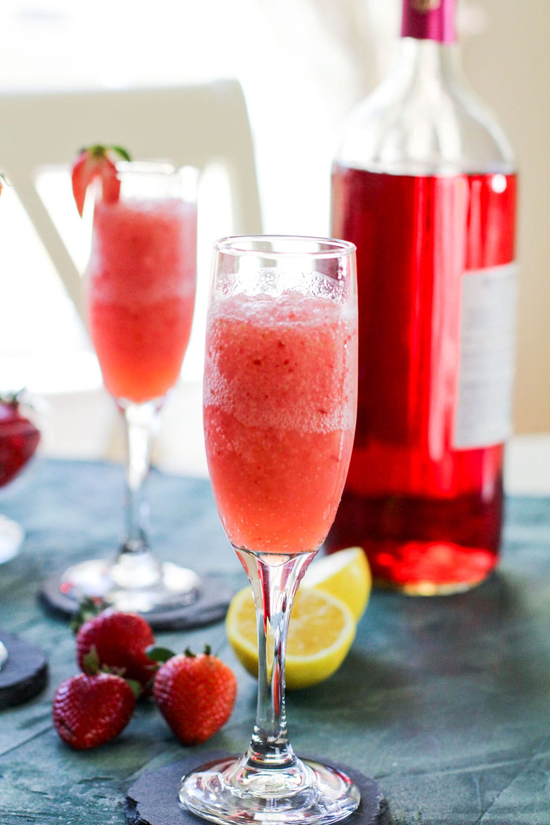 close up of a rose bottle and 2 froze cocktail glasses