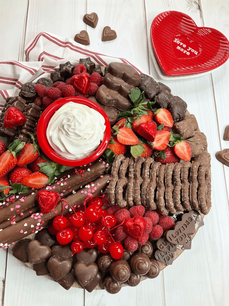 Valentine's Chocolate Charcuterie board with some random chocolate hearts surrounding it. 