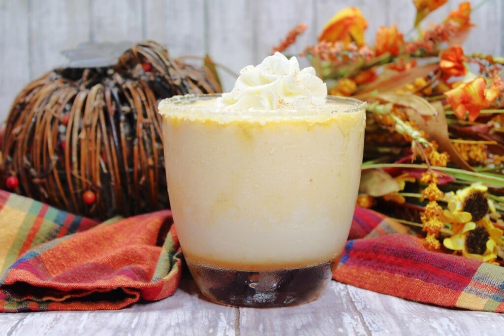Salted Caramel Pumpkin Martini Recipe: Clear glass with creamy drink in it topped with whipped cream. 
