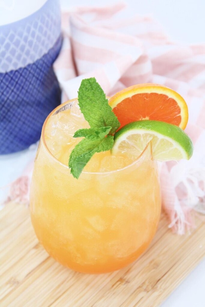 top view on garnish of mint leaves, lime wedge, and orange slice in cocktail 