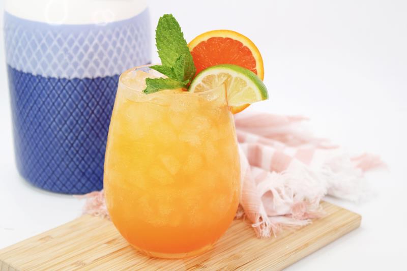 showing completed sunny savannah cocktail with mint, lime, and oranges as garnish. 