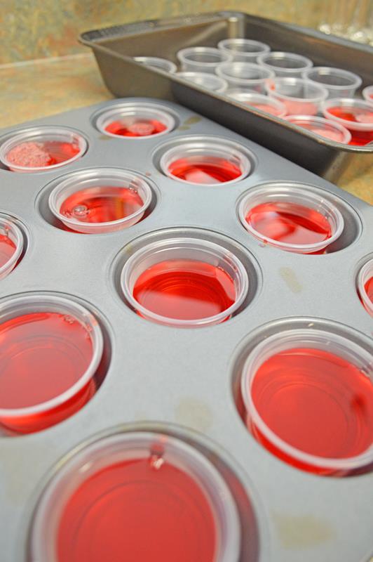 Muffin tin with jello shot container filled with jello mix 