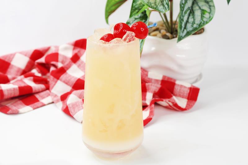 tropical orgasm cocktail recipe light orange drink in glass topped with cherries