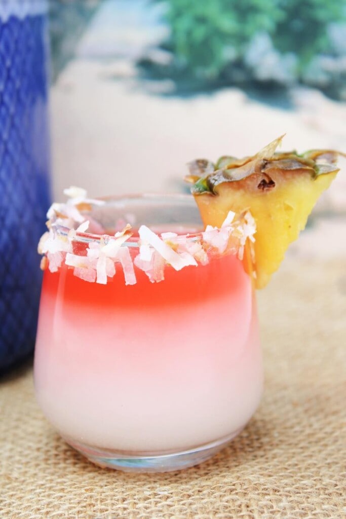close up of drink with coconut rim and pineapple wedge 