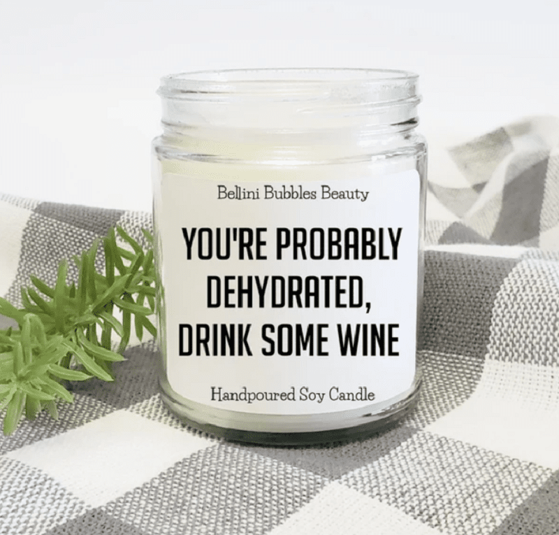 white candle in jar that says You're probably dehydrated, drink some wine