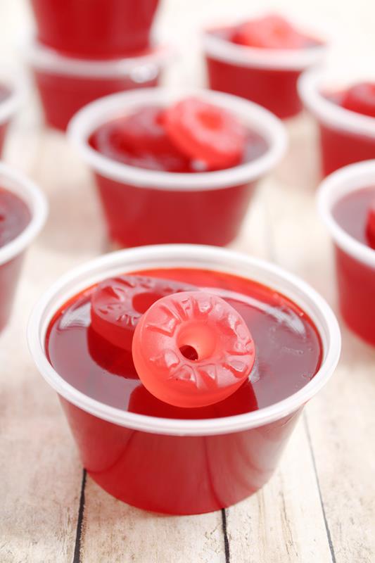 Lifesaver Jello Shot Recipe - Showing close up of a completed red jello shot with two slightly different colored gummy life savers on top. 