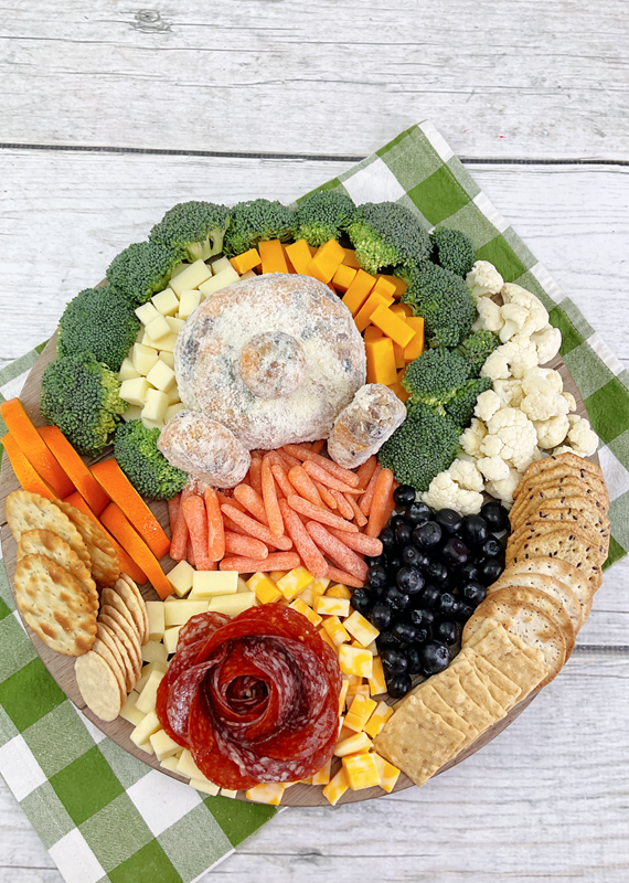 Above view of completed board showing bunny bum cheese ball and various fruit, vegetables, cheese, and crackers. 
