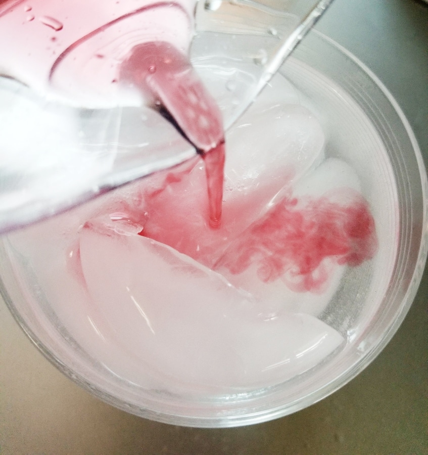 cranberry juice being poured into glass 