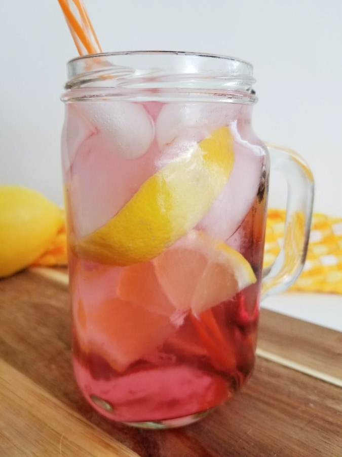 completed orange and vodka cocktail with ice and lemon floating in drink 