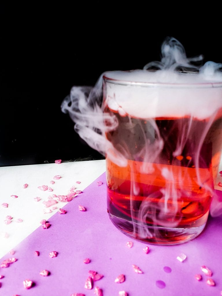 Aladdin inspired cocktail with dry ice and fog pouring over the side