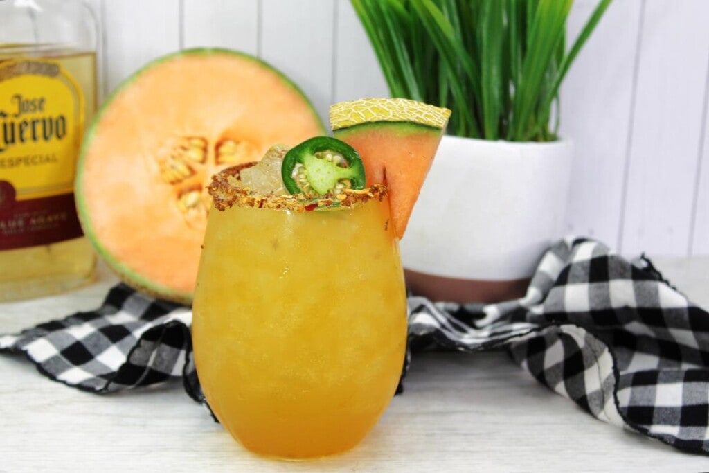 Jalapeno Cantaloupe Margarita - Cocktail topped with jalapeno, cantaloupe wedge and spicy salted rim. 
