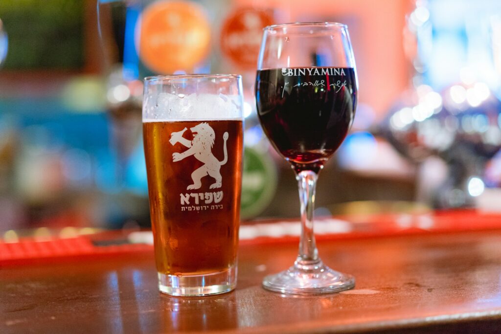 Glass of wine and beer next to each other on a bar